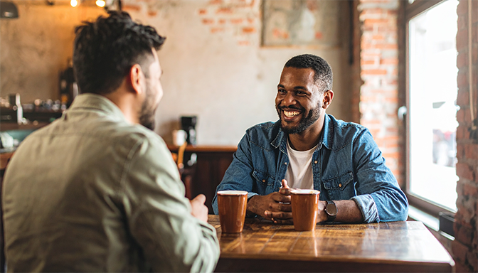 men sitting at small cafe table