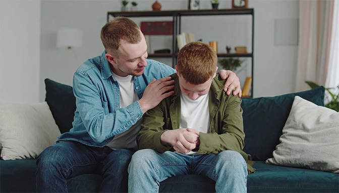 parent speaking calmly to upset teenager
